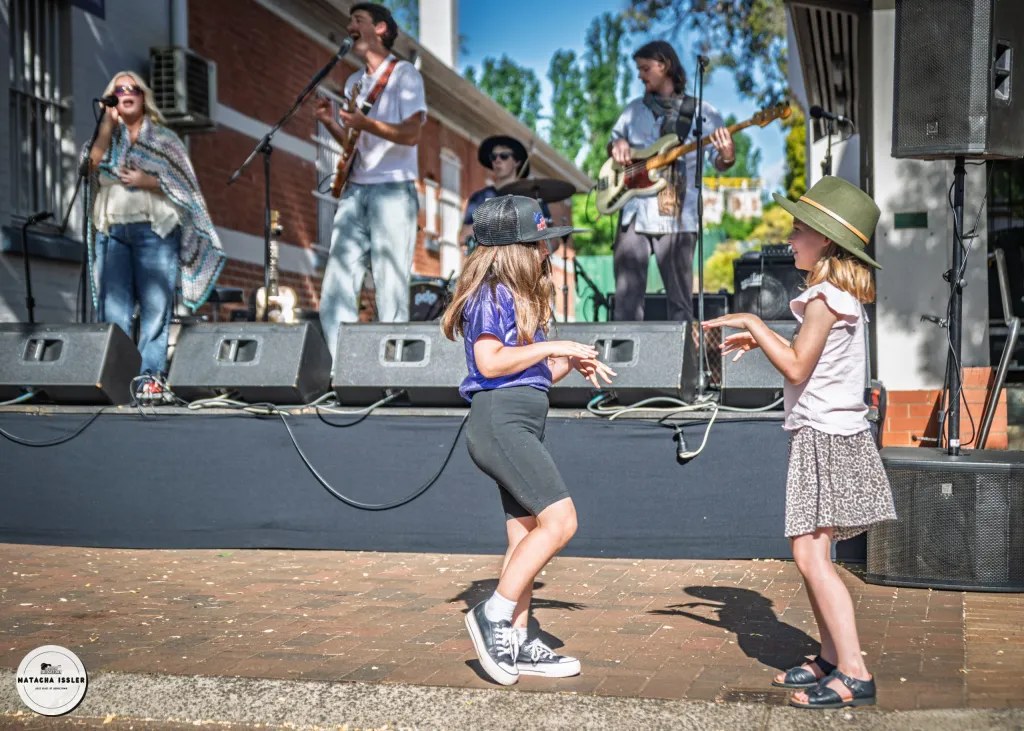 Children dancing in front of a live band on a Blues at Bridgetown street stage.