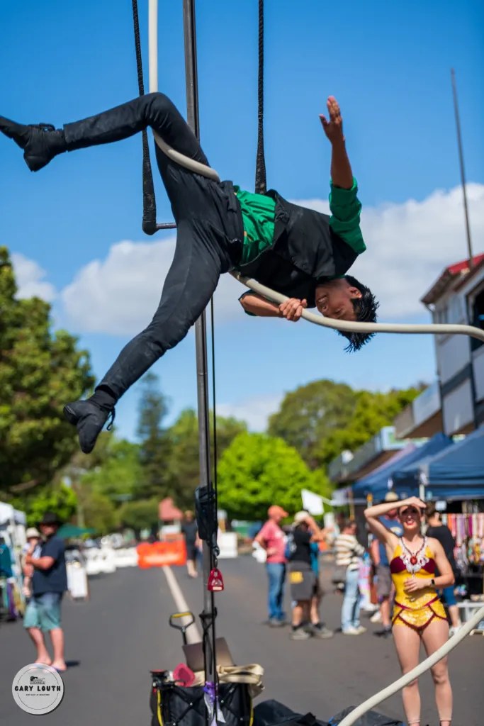 An acrobat performs above the crowd at the Blues at Bridgetown Street Party.
